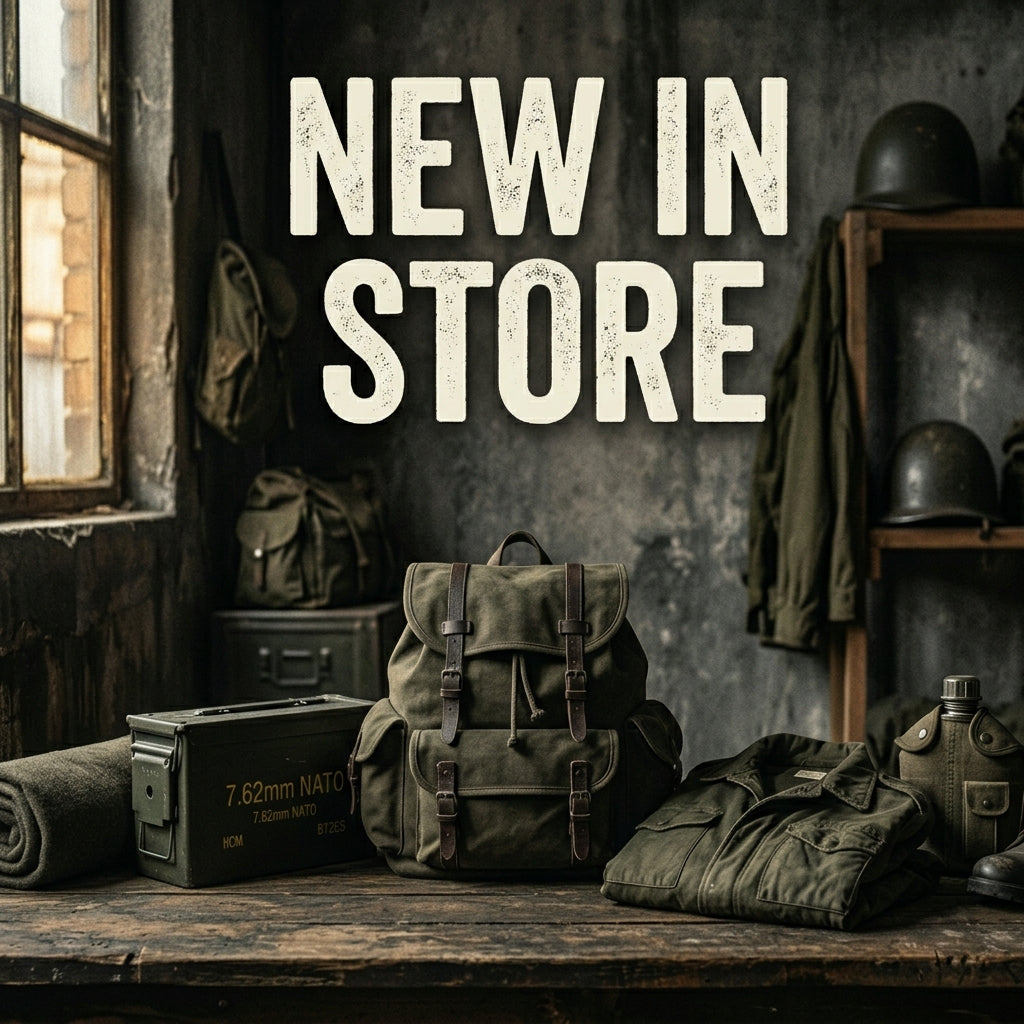 Rustic wooden workbench featuring a new canvas tactical backpack, military field jacket, and gear, with text reading New In Store.