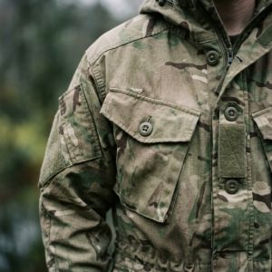 An assortment of British military specialist cold-weather garments arranged on a slate surface.