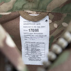 Close-up of British Army military issue label with NSN number, NATO size, and 50/50 polycotton fabric specification