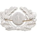 Rear view of DDR NVA visor cap badge showing lightweight stamped aluminum surface and dual bendable brass split-pins