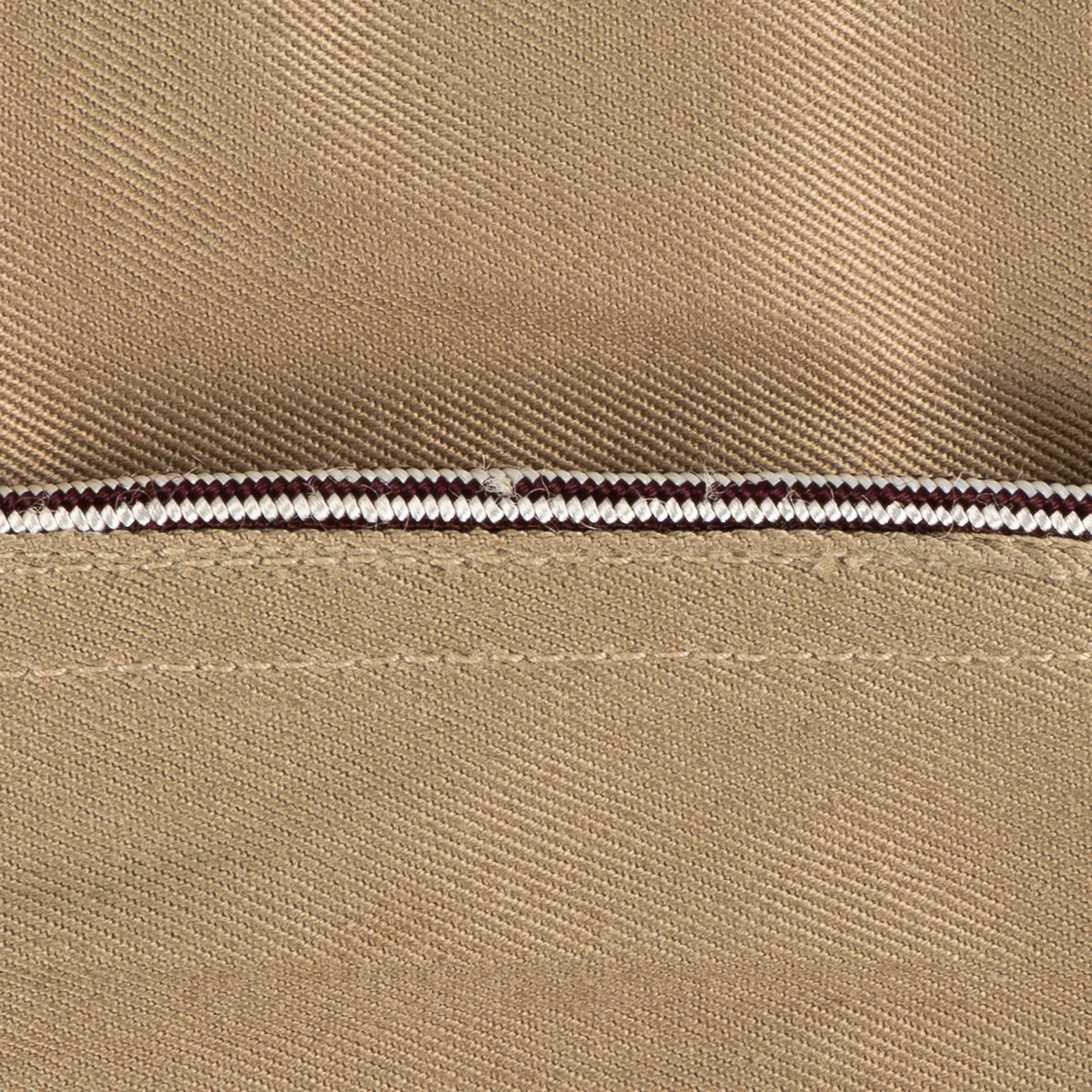 Close-up of brown and white checkered piping on a vintage WW2 US Army Khaki Garrison Cap.