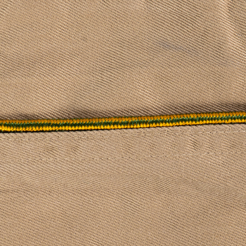 Close-up of green and yellow braided piping detail on an original WW2 US Army Garrison Cap.