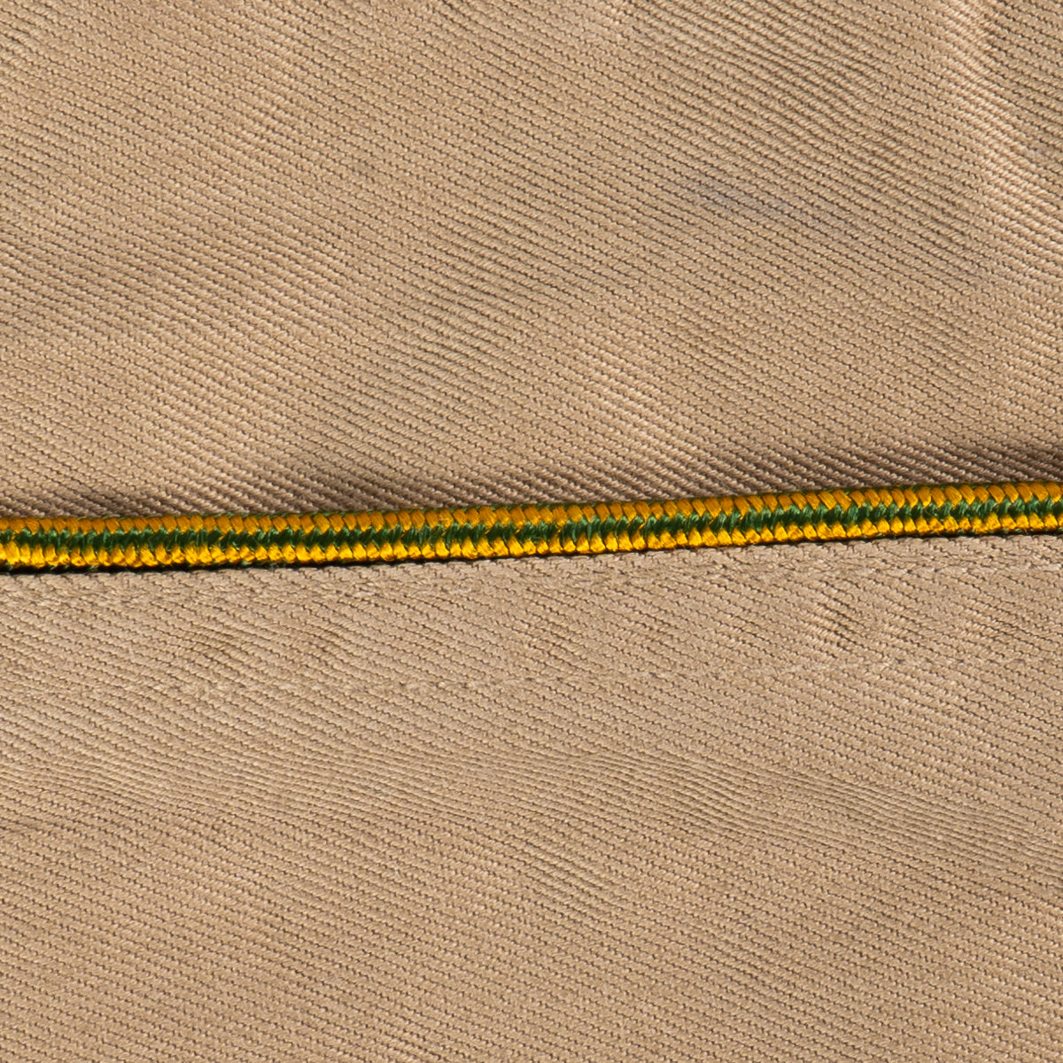 Close-up of green and yellow braided piping detail on an original WW2 US Army Garrison Cap.