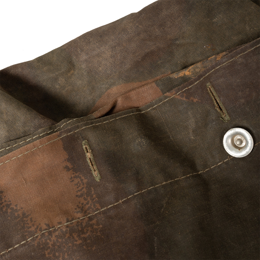 Close-up of the durable canvas fabric of a Hungarian Zeltbahn showing buttonholes and metal button fasteners.