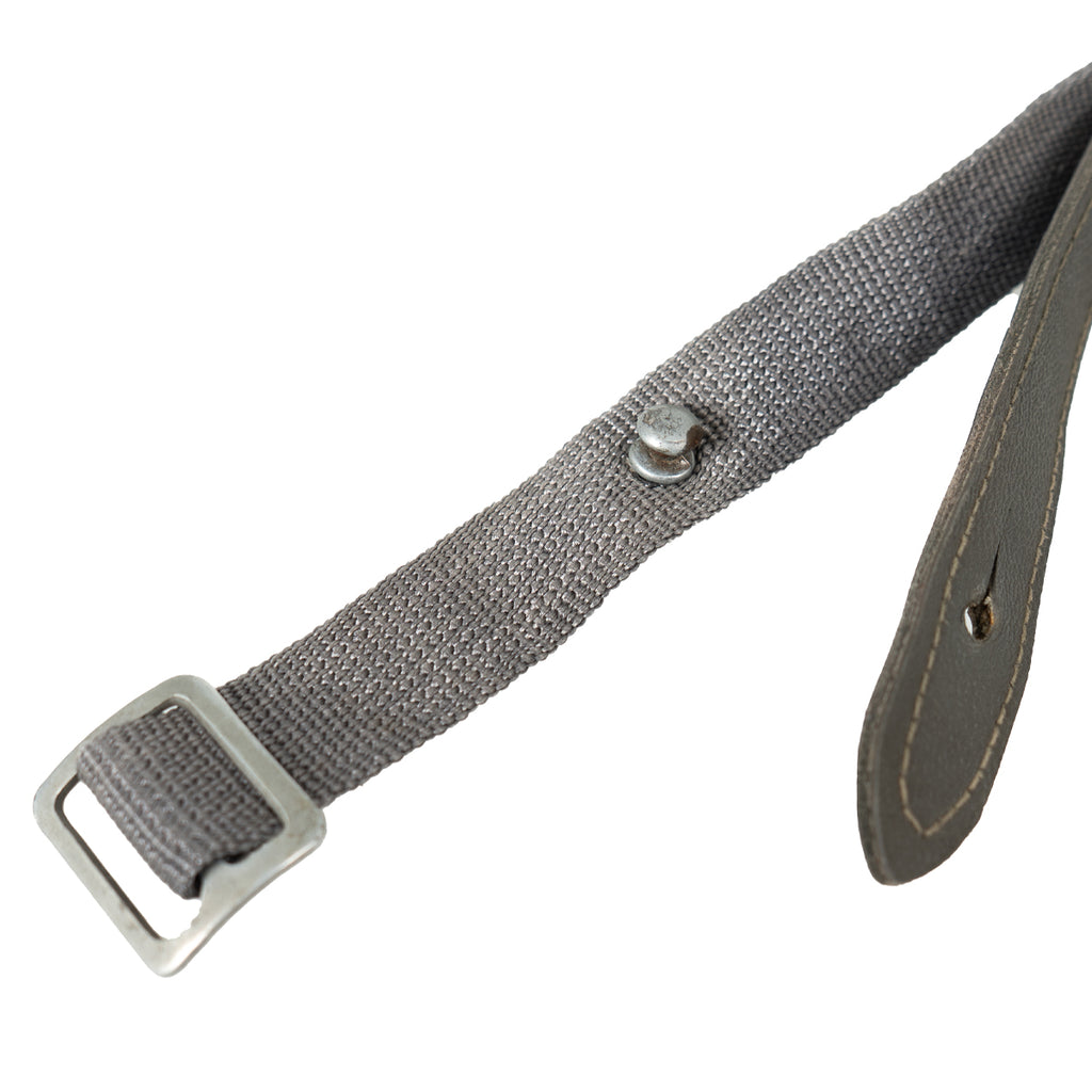 Close-up of the East German NVA equipment strap, highlighting the zinc-plated slide buckle and the mushroom stud for securing the Lederol tab.