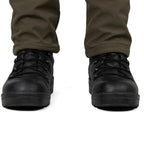 Front view of black tactical boots worn with olive trousers, showing the rounded toe and robust ankle support.