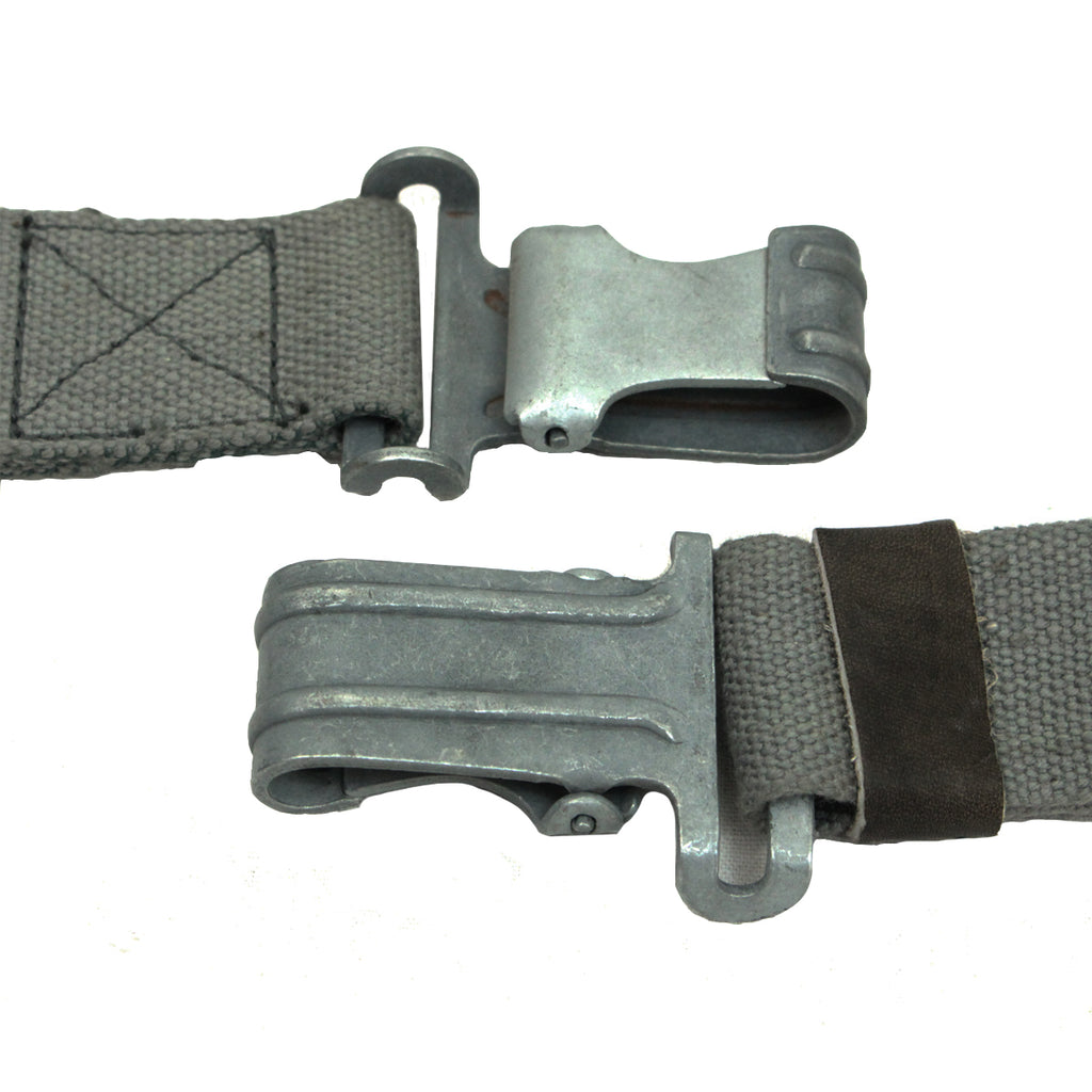 Close-up detail of two metallic spring-loaded clips on an authentic East German RPG7 surplus sling showing the grey steel finish.