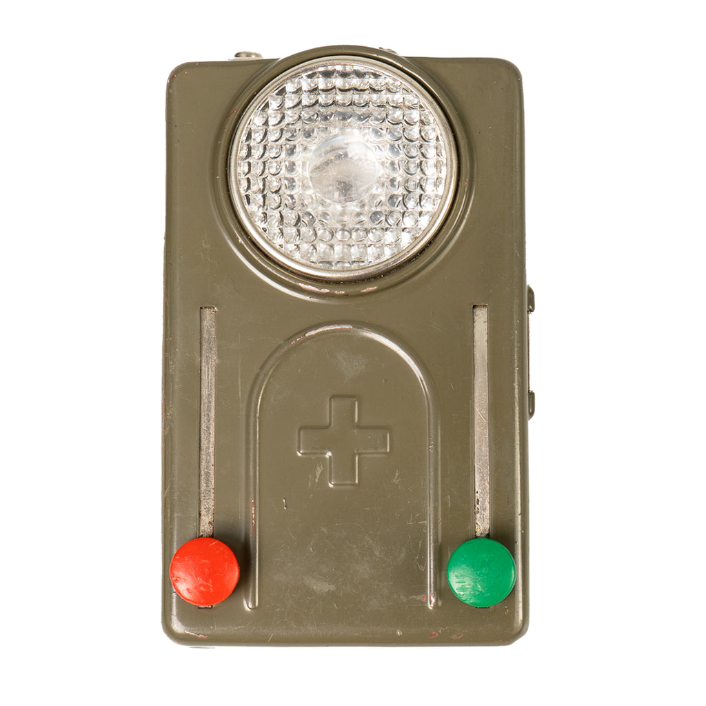 Original Swiss Army Type 1 pocket signalling lamp with olive-drab metal casing, textured lens, and red and green circular filters.
