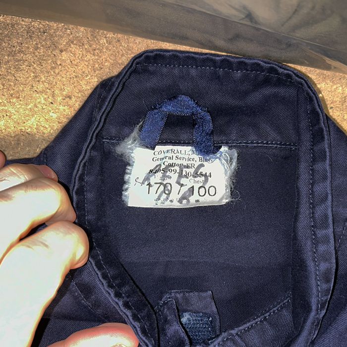 Close-up of the official military label on British Navy cotton FR coveralls showing NSN and size