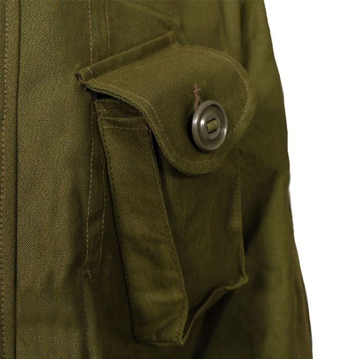 Close-up of the angled chest pocket on the Canadian combat jacket showing the slotted tape Canadian button and sateen fabric.