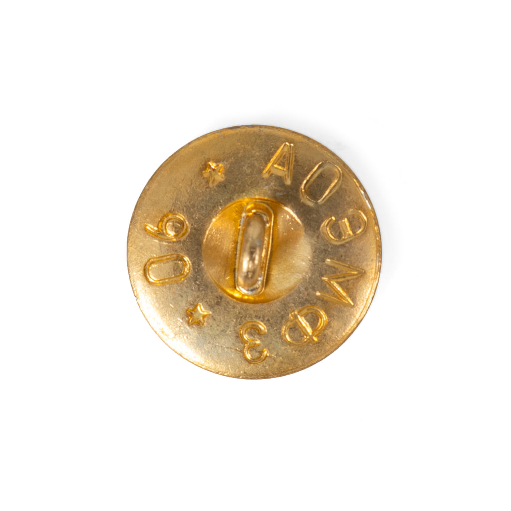 Reverse side of a 1990 Soviet military brass button, showing the wire loop shank, Cyrillic factory markings, and stamped production year.