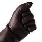 Flexible dark brown Dutch Army unlined glove on hand forming a fist to demonstrate leather suppleness