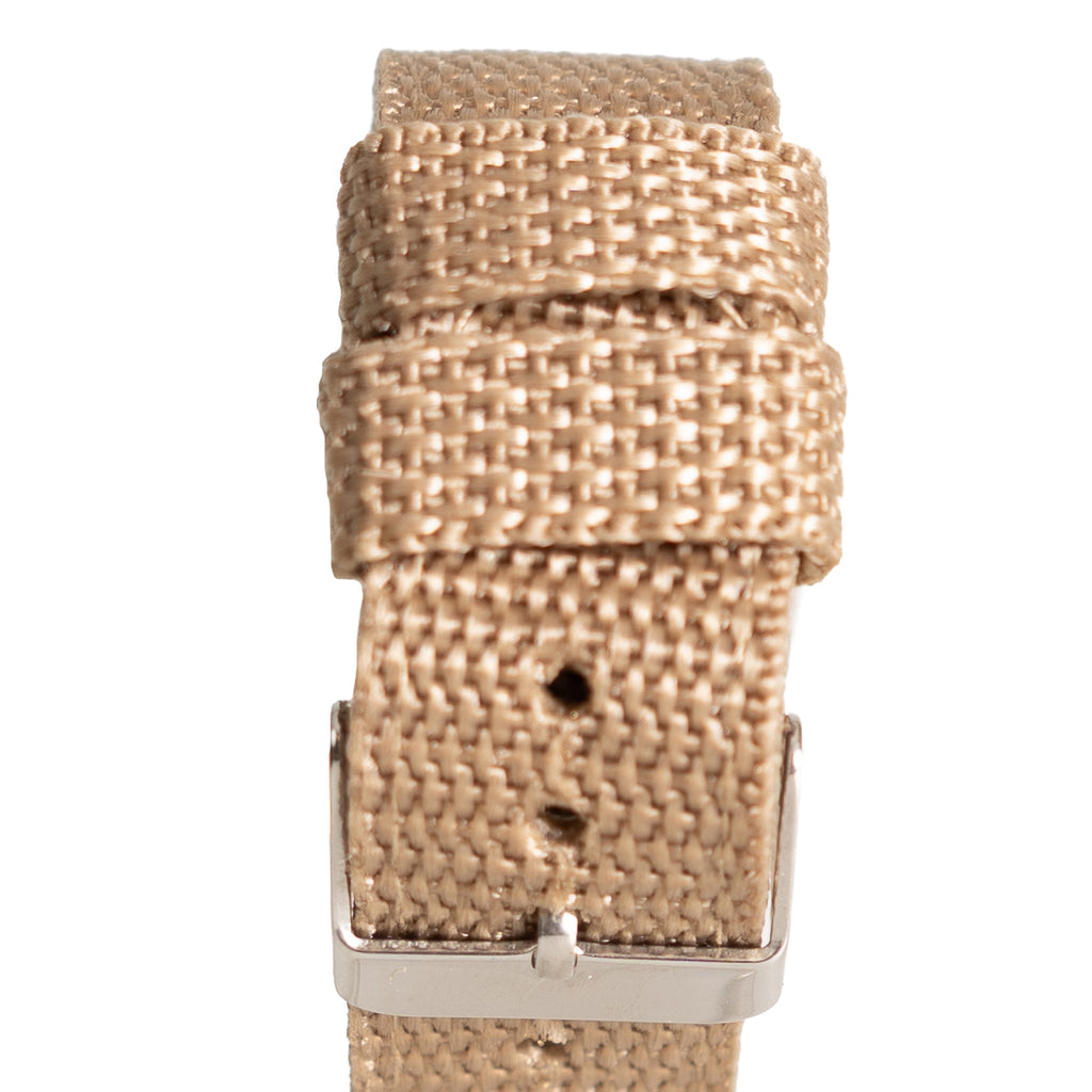 Detailed view of the durable tan canvas watch strap, showing the woven fabric texture and metal pin buckle clasp.