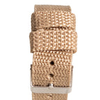 Detailed view of the durable tan canvas watch strap, showing the woven fabric texture and metal pin buckle clasp.