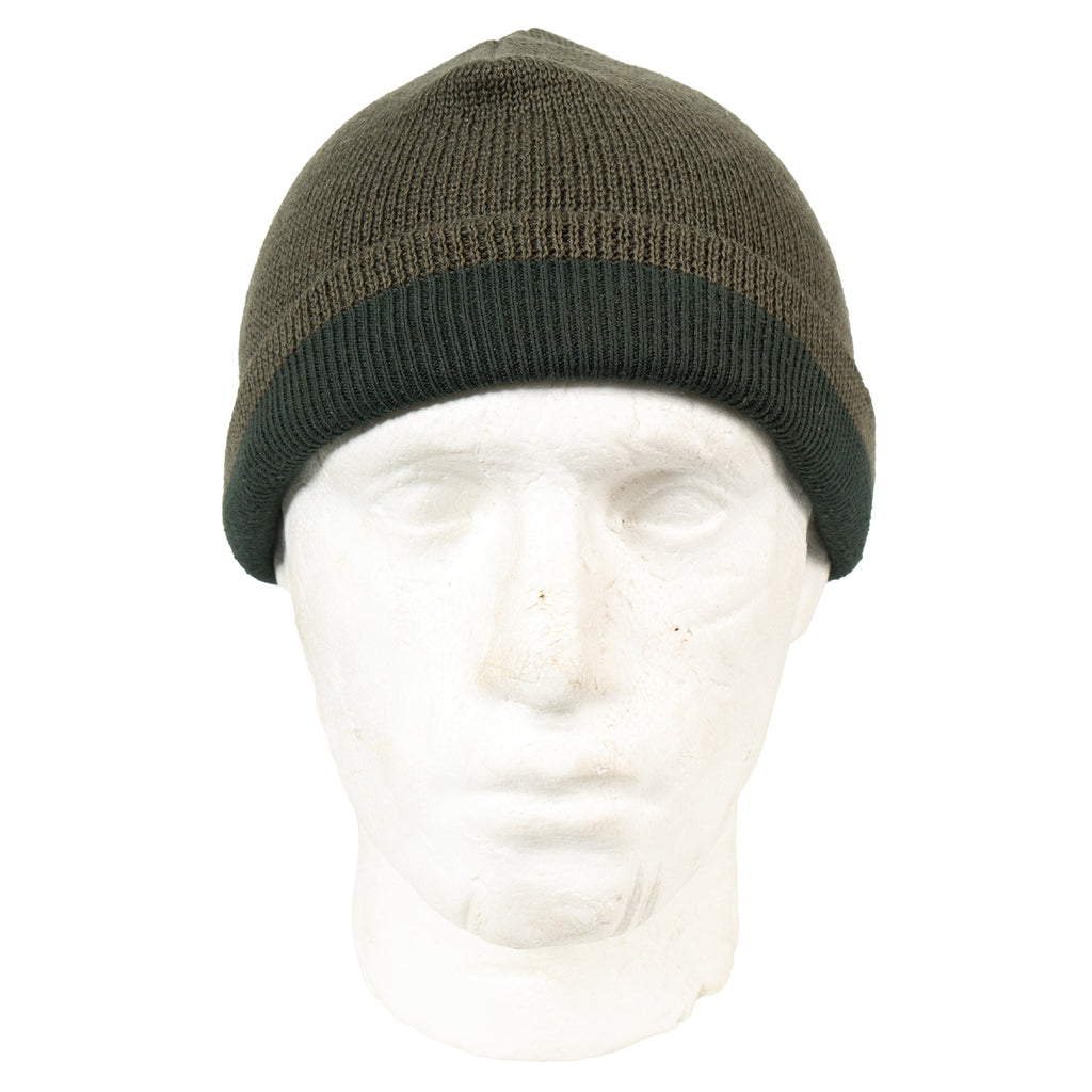 Austrian Army wool beanie worn as a folded watch cap on a mannequin head, showing the olive drab knit and contrasting dark green brim.