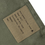 Close-up of military issue tag on 2017 British Army sweat rag showing NSN 8420-99-975-7529 and tropical green fabric.