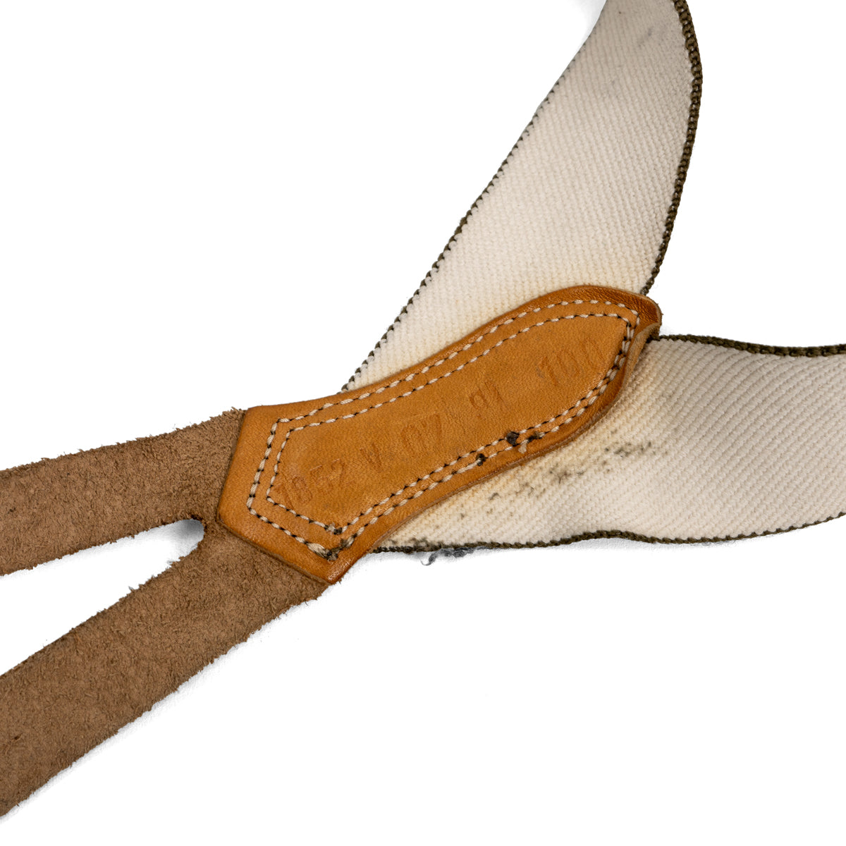 Close-up of the Bundeswehr surplus braces central leather connector, showing authentic stitched details and stamped markings on tan leather.