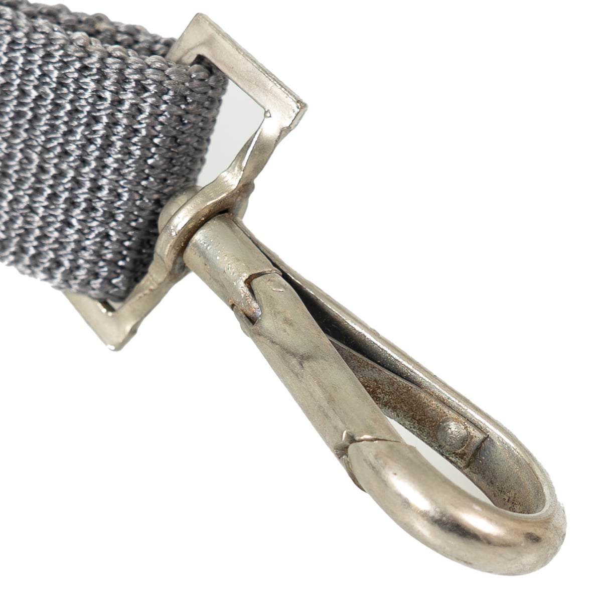 Close-up detail of the steel snap hook on an original East German NVA rifle sling, showing the durable construction and vintage military finish.