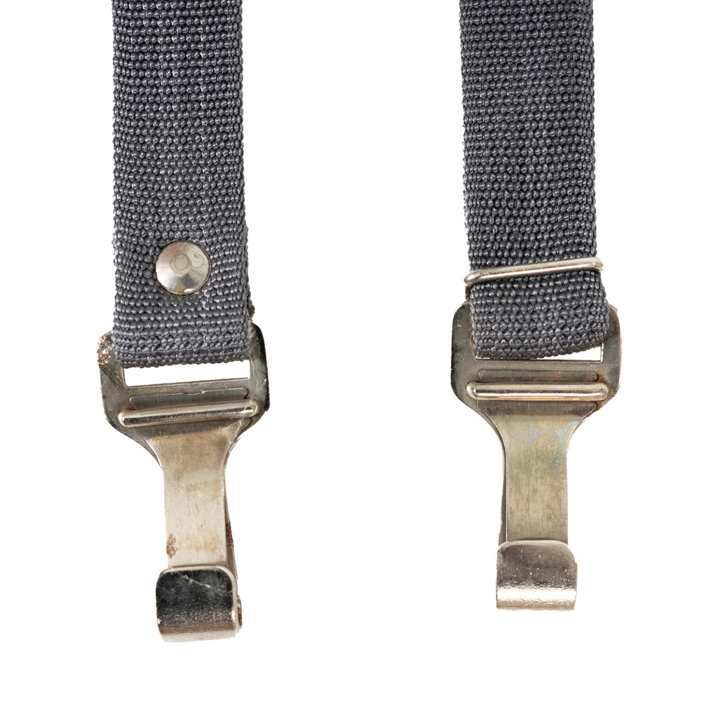 Close-up of the robust flat steel snap hooks and metal rivets on the genuine East German NVA surplus equipment strap.