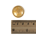 Close-up of the 22mm gold-tone Soviet uniform button placed next to a centimeter ruler to demonstrate its exact diameter for restoration projects.