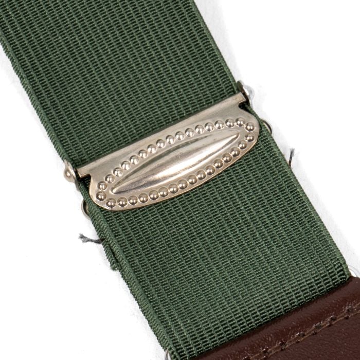 Close-up of textured metal slider adjuster buckle on green elastic webbing strap