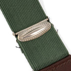 Close-up of textured metal slider adjuster buckle on green elastic webbing strap