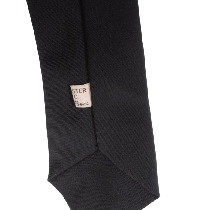 Detailed view of tag and rear seam stitching on black uniform tie