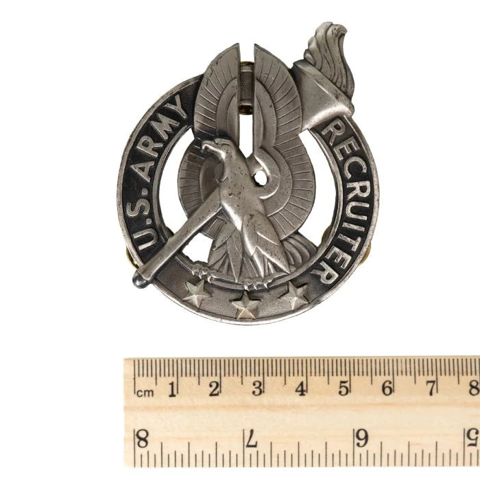 Front of US Army Recruiter Badge next to wooden ruler showing dimensions of 5.4 cm