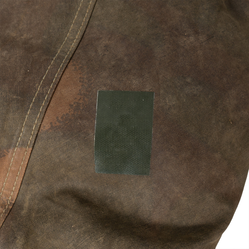Detailed view of a green adhesive patch on the waterproof canvas material of the Hungarian tent.