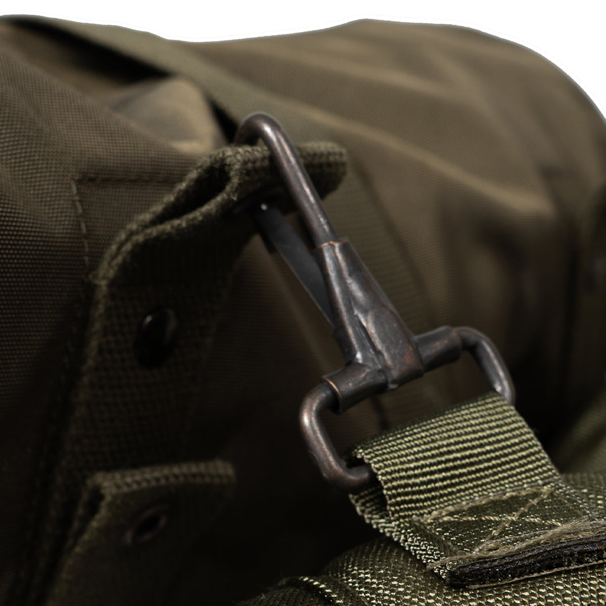Close-up of a green bag with a buckle and strap on a blurred background