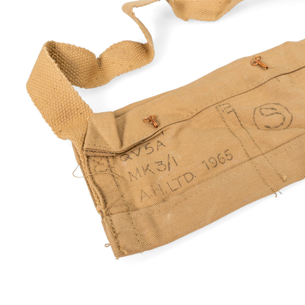Close-up of markings on a 1965 British Army bandolier, detailing manufacturer and year on durable tan cotton construction.