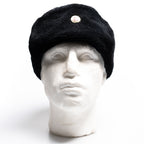 Front view of an authentic East German military Ushanka hat with ear flaps secured upward on a mannequin.
