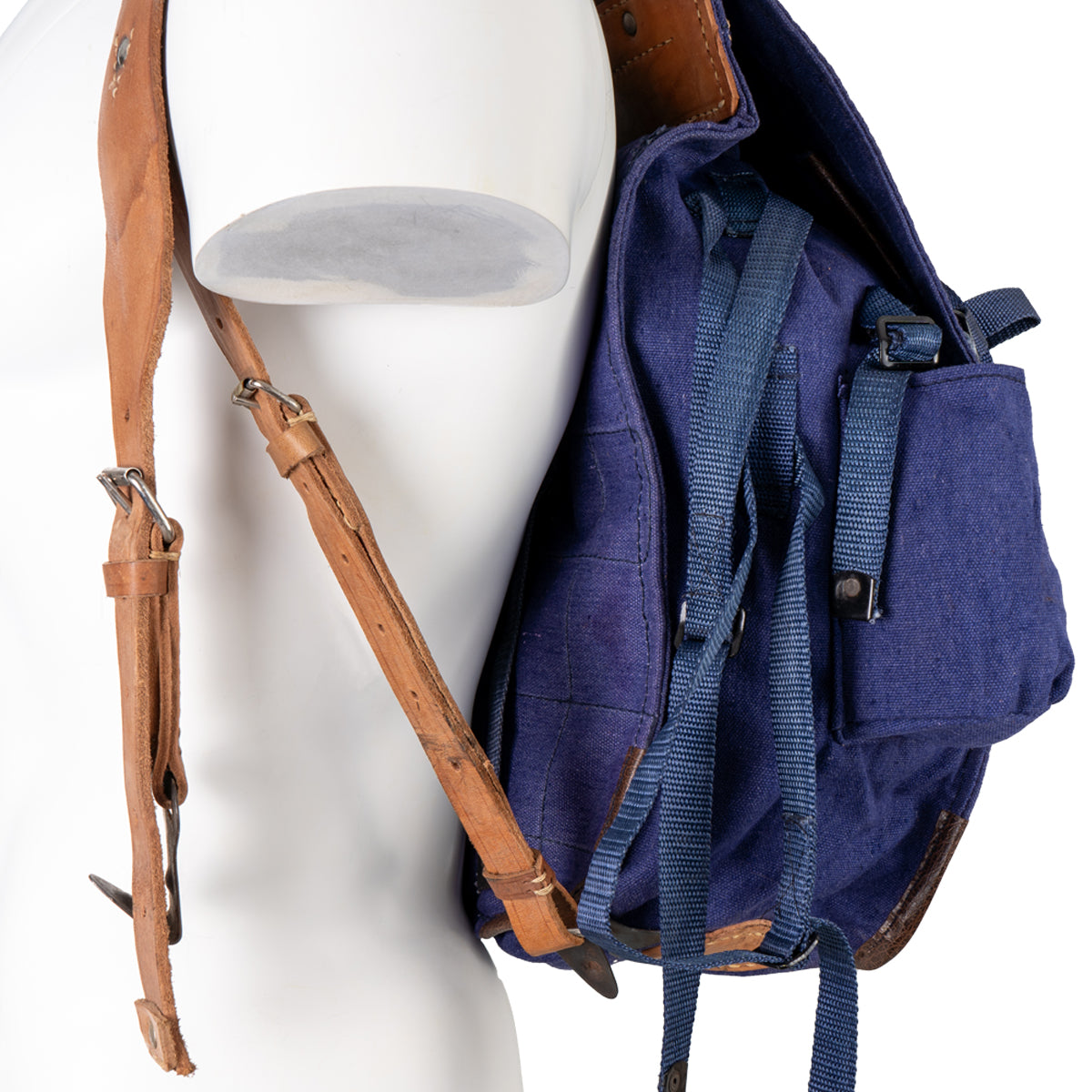 Close-up detail of the durable vegetable-tanned leather shoulder straps and blue cotton canvas construction of the Romanian surplus pack.