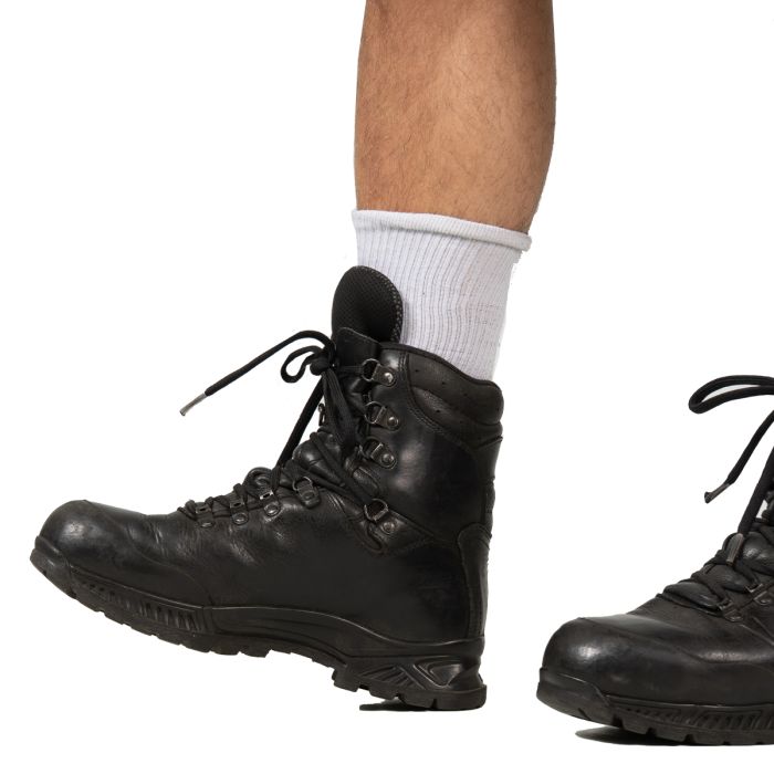 Profile view of a laced-up Haix black leather boot being worn, showing the flexible ankle crease and secure fit.