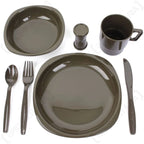 Top down view of olive drab camping plate bowl mug knife fork and spoon