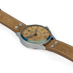 Three-quarter angle showing the bevelled domed glass crystal, matte case finish, and cream dial markings