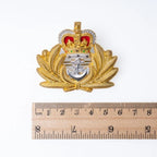 Original British Royal Navy Officer cap badge placed next to a ruler measuring approximately 5.5 centimetres in width