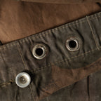 Close-up of the reinforced metal eyelets and aluminium buttons along the edge of the Zeltbahn tarp.