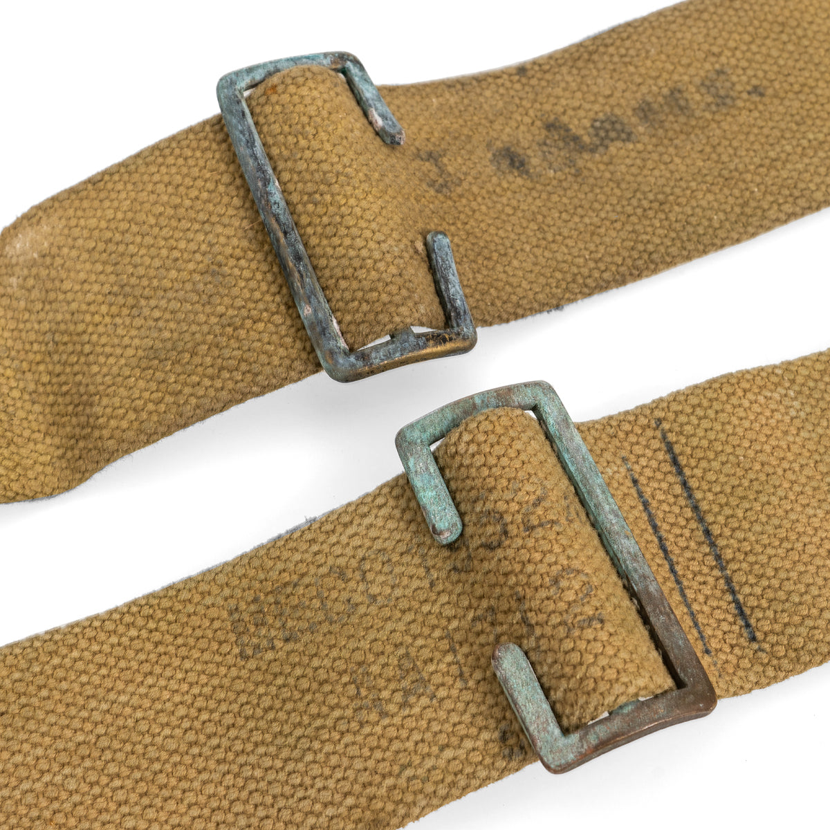 Detailed view of metal adjustment buckles on original 37 Pattern L-straps with visible vintage owner markings on the cotton canvas.