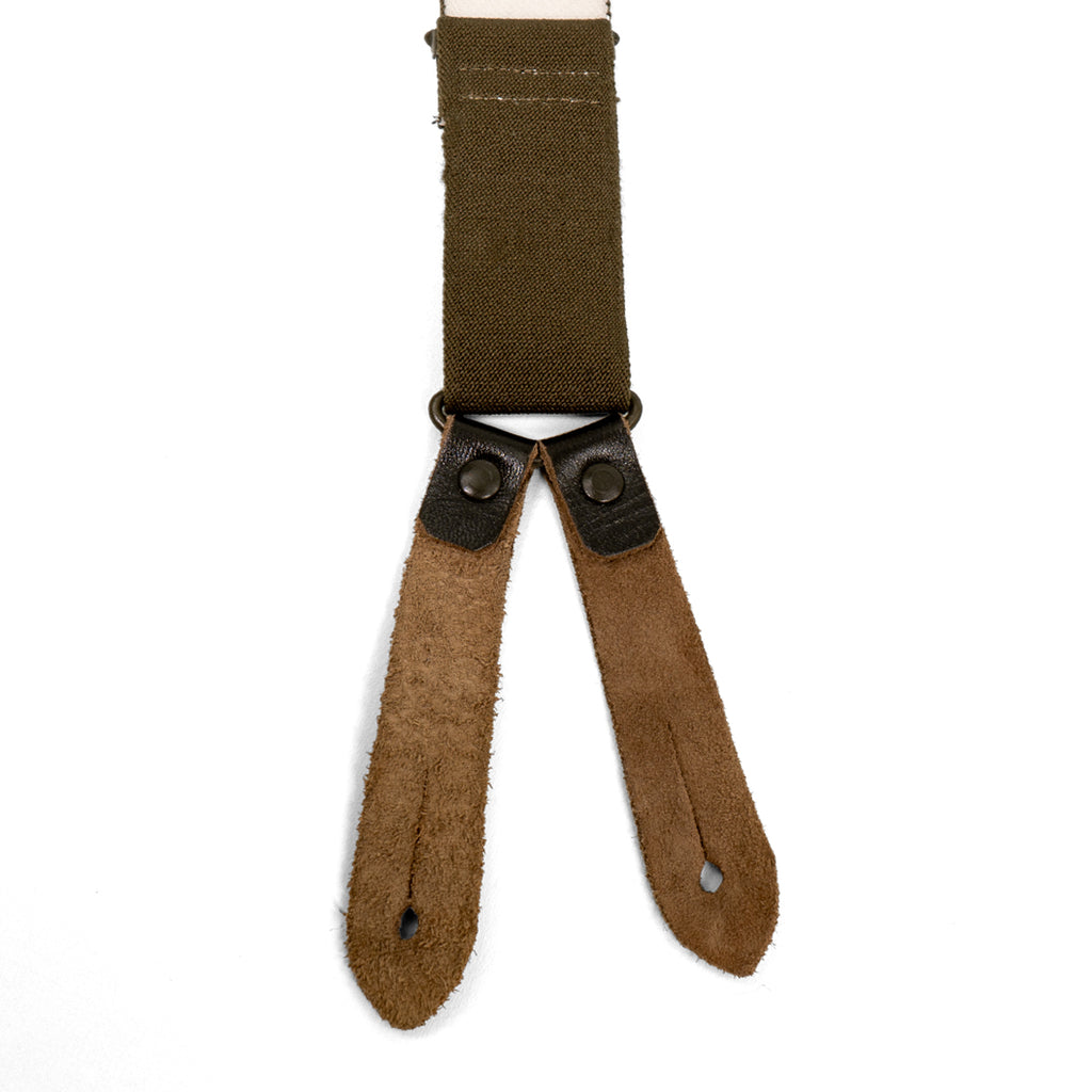 Reverse view of Bundeswehr suspender leather tabs, showing the natural suede texture and buttonhole details for secure trouser attachment.