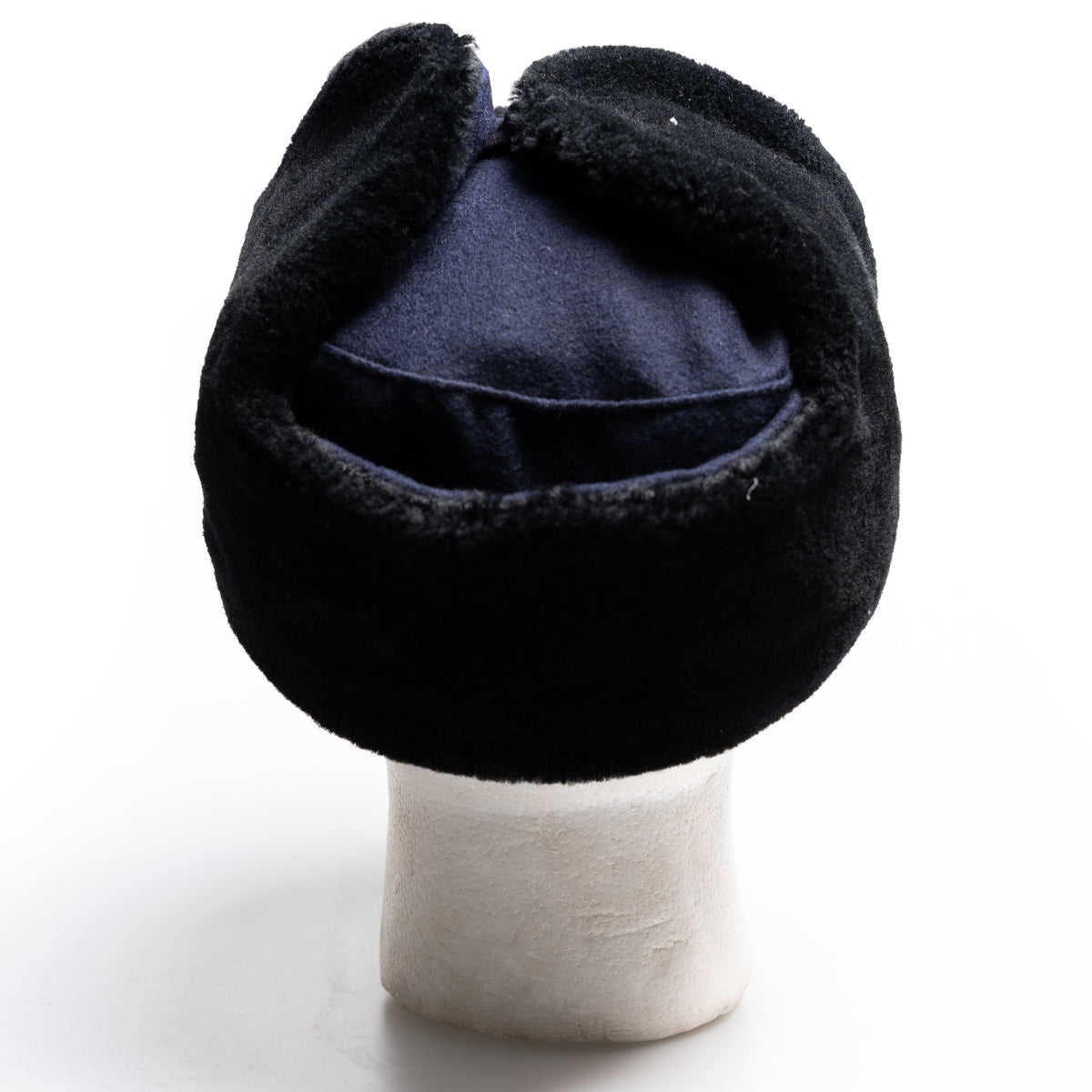 Rear view of a navy blue surplus East German Army Ushanka hat, showcasing the durable construction and folded ear flaps.