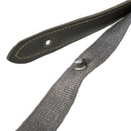 Macro view of the NVA strap's attachment mechanism, featuring the stitched Lederol tab and the metal mushroom stud used in East German battle packs.
