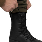 Close-up of a hand tightening the laces on a German KS2005 combat boot, displaying the speed-lacing hardware.