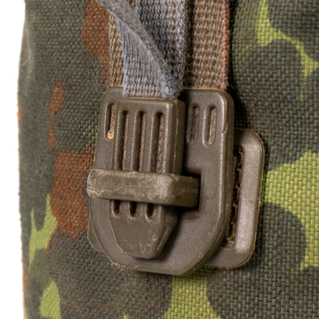 Close-up detail of the Spanish-style quick-release buckle on a Flecktarn camouflage canteen pouch, demonstrating its secure locking mechanism.