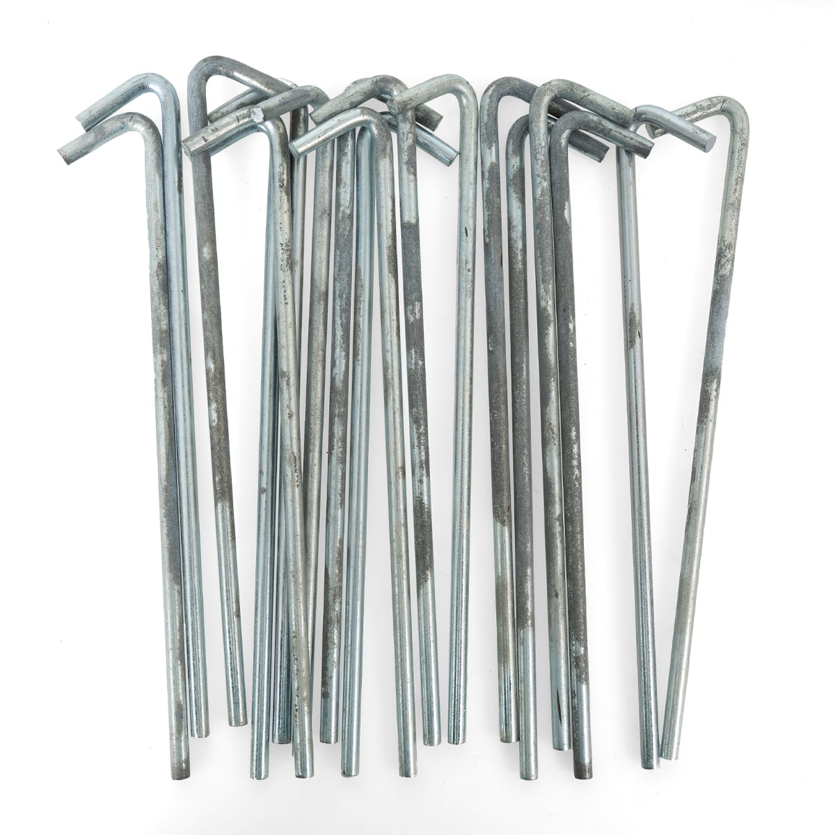 Collection of approximately 10 galvanised steel tent pegs in surplus condition with typical signs of wear and rust.