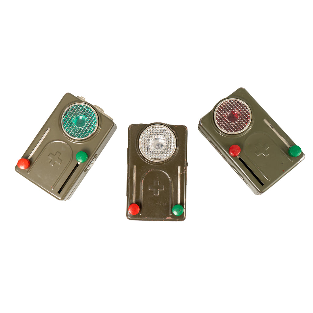 Three Cold War era Swiss Army signalling torches showing variations in red, green, and clear lens positions.