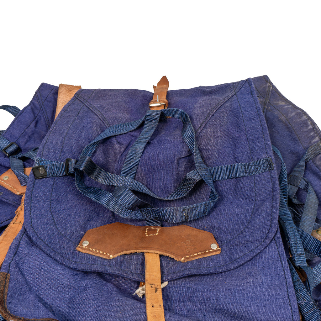 Detailed view of the top lid on the Romanian Cold War rucksack, showing the reinforced leather attachment point and blue webbing gear straps.