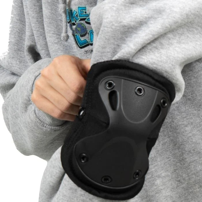 Black Rothco Low Profile Tactical Elbow Pad fitted on user arm over jacket sleeve