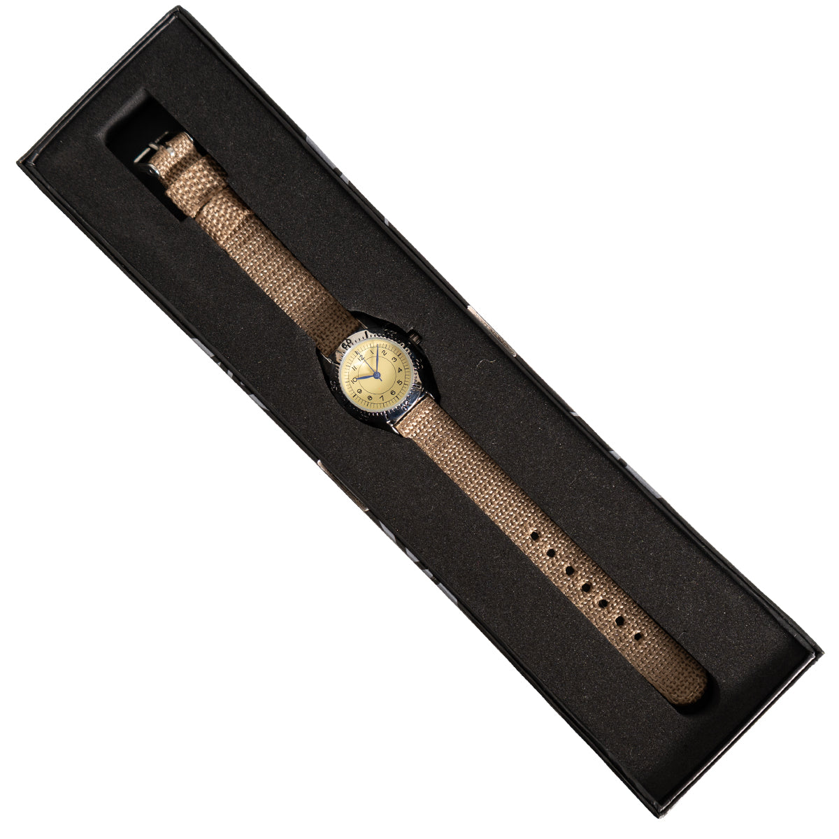 Vintage-style pilot watch presented in a black foam-lined display box, showcasing the compact 28mm case and canvas strap.