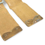 Bottom ends of British Army 37 Pattern L-straps featuring reinforced brass tips with eyelet holes, showing historical signs of use.